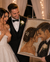 Bride and groom smiling beside a large framed custom rhinestone portrait of them, photographed in a wedding setting with warm string lights in the background.